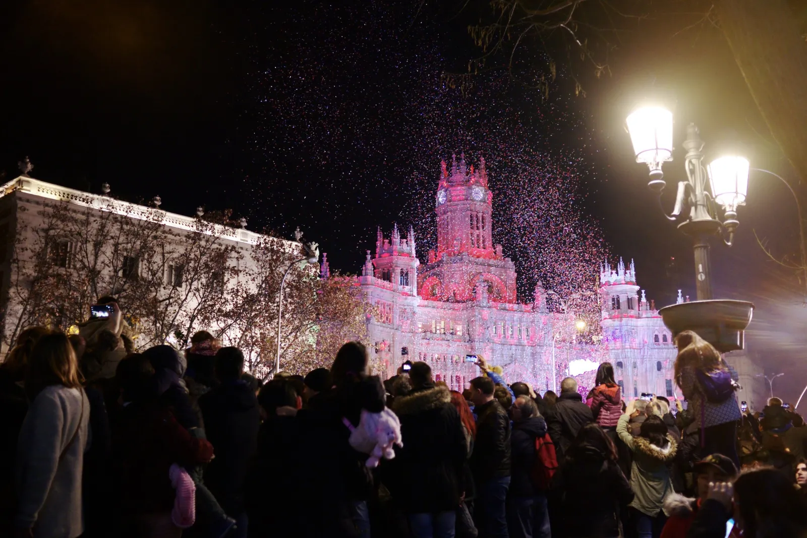 Público viendo caer el confeti sobre la plaza de Cibeles al final de la Cabalgata de Reyes de Madrid